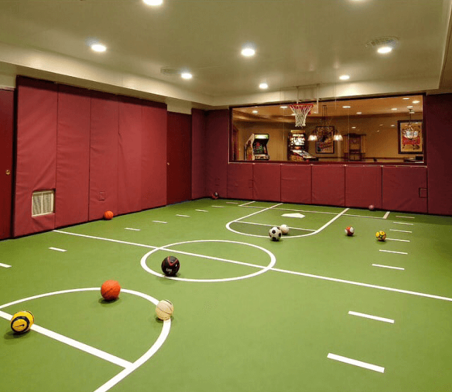 Residential indoor home court with basketball and other sports equipment.
