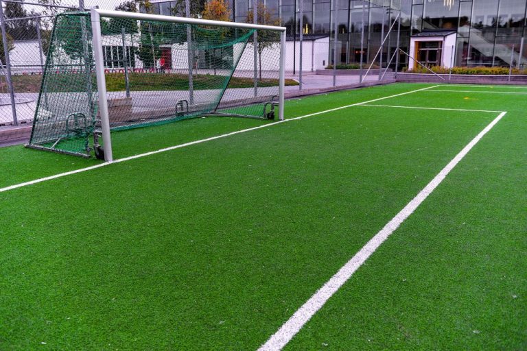 A commercial outdoor athletic court featuring a soccer field with a centrally placed goal.