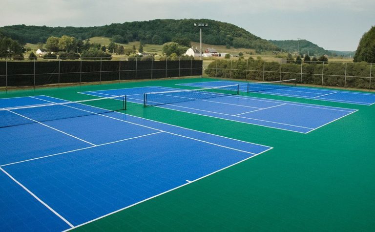 A tennis court with blue and white lines.