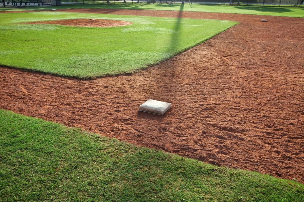 A baseball field design featuring an indoor facility and a dirt mound in the middle.