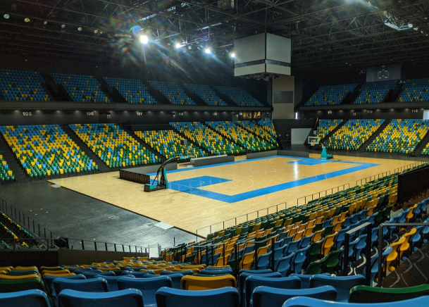 An empty basketball court with blue seats at a Geo Site in Florida.