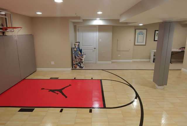 A basketball court in a basement with a basketball hoop located in Florida.