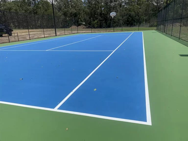 A tennis court with blue lines for Pickleball.